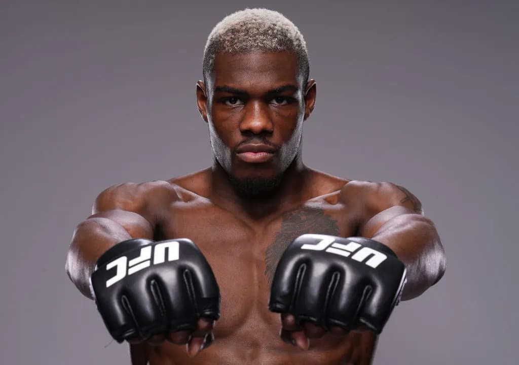 Portrait d’Oki Bolaji, poings tendus vers l’objectif